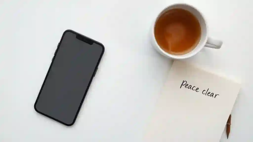 Phone facedown beside tea and a journal symbolizing emotional boundaries and closure.