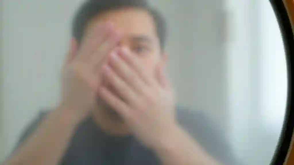 Person wiping a fogged mirror, representing emotional clarity and self-honesty.