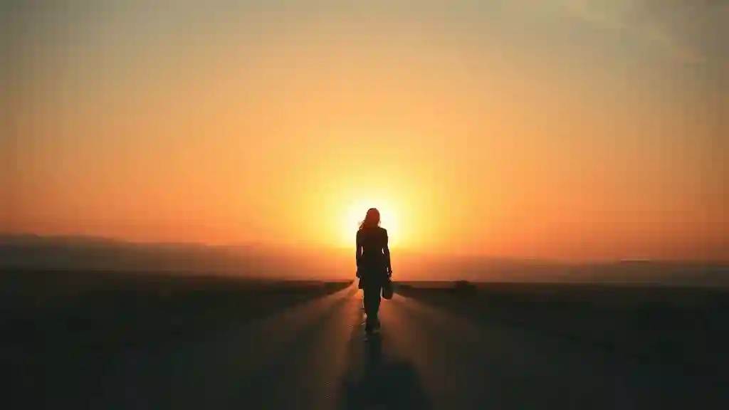 Silhouette walking toward sunrise, symbolizing closure and emotional freedom.