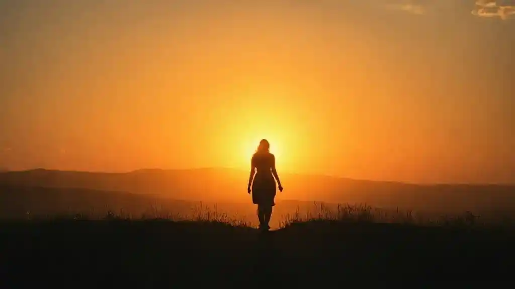Silhouette of a woman walking into sunrise representing hidden feelings becoming visible.